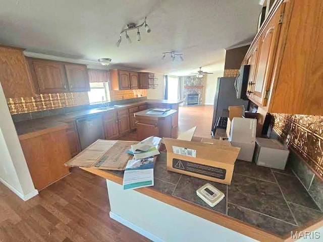 kitchen featuring dishwasher, a ceiling fan, stainless steel microwave, tasteful backsplash, and a sink