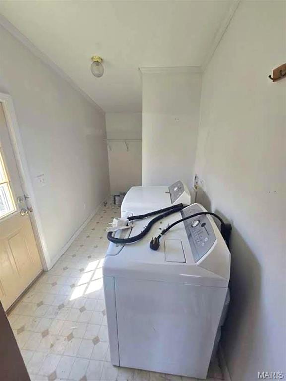 clothes washing area featuring washer / dryer, ornamental molding, and light floors