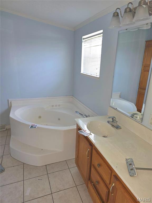 bathroom featuring ornamental molding, a tub with jets, tile patterned flooring, and vanity