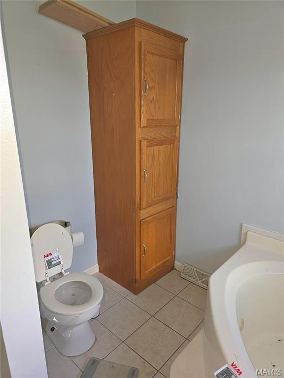 bathroom featuring tile patterned floors, toilet, and baseboards
