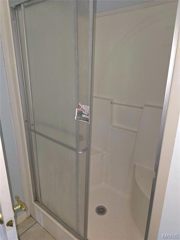 full bathroom with a stall shower and tile patterned floors