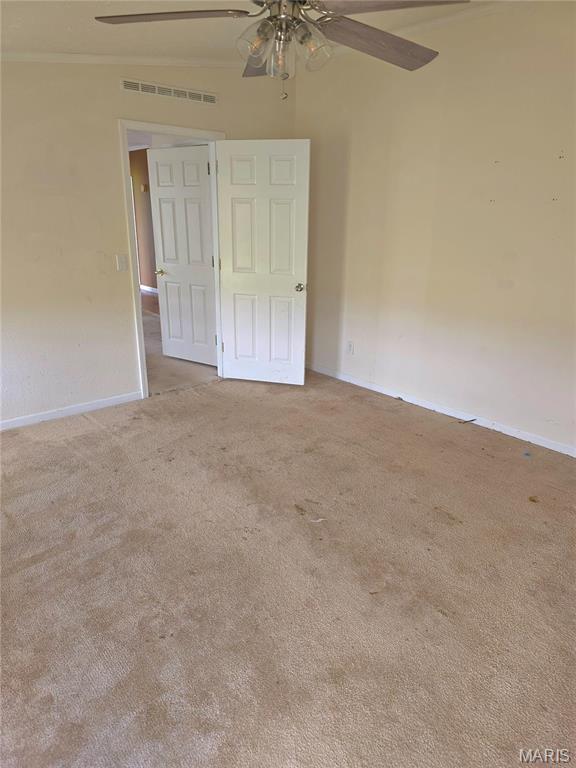 unfurnished bedroom featuring carpet flooring, baseboards, a ceiling fan, and ornamental molding