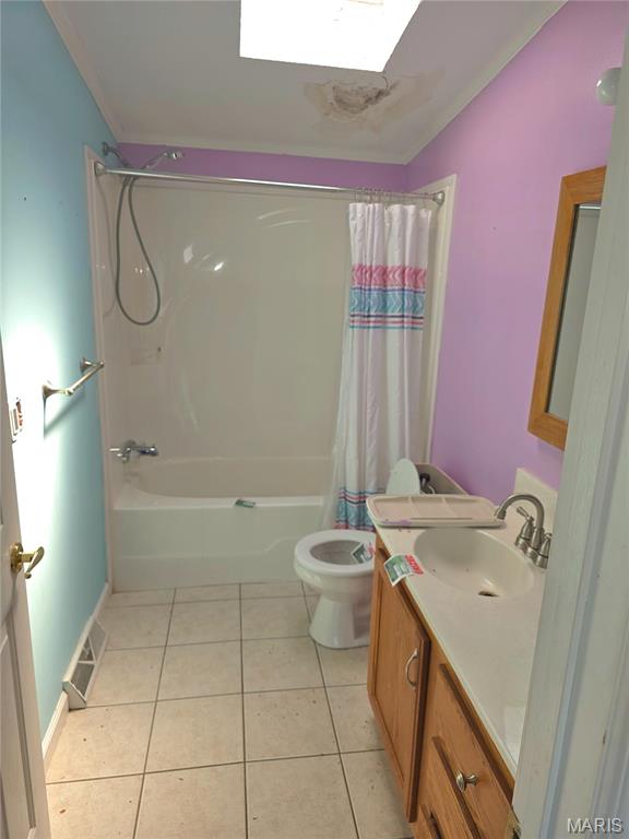 full bath featuring tile patterned floors, shower / tub combo, vanity, toilet, and vaulted ceiling