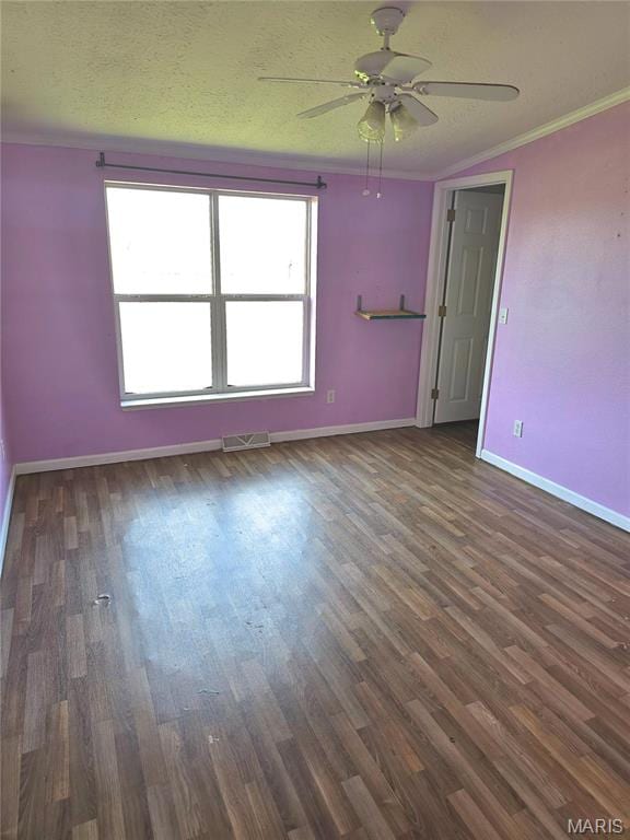 empty room with ornamental molding, baseboards, a ceiling fan, wood finished floors, and a textured ceiling
