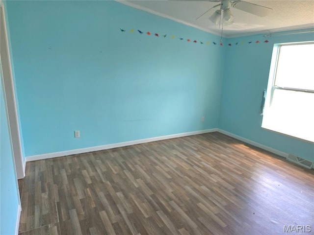 spare room with wood finished floors, a ceiling fan, baseboards, and ornamental molding