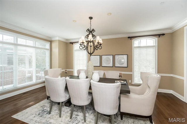 dining room with a chandelier, dark wood-style flooring, crown molding, and baseboards