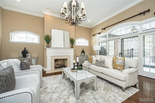 living area featuring healthy amount of natural light, a chandelier, wood finished floors, recessed lighting, and crown molding