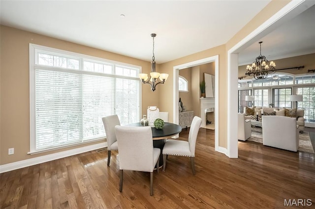 dining space featuring a chandelier, baseboards, and plenty of natural light