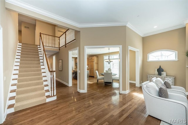 entrance foyer with wood finished floors, ornamental molding, stairs, baseboards, and healthy amount of natural light
