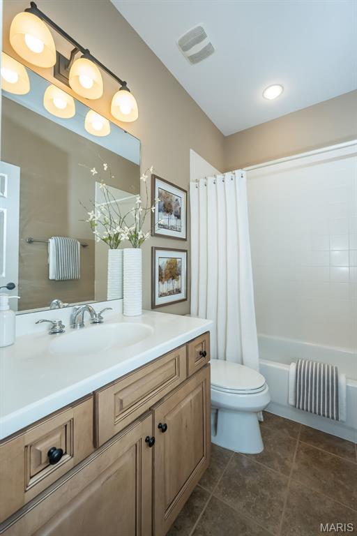 full bathroom with toilet, vanity, tile patterned flooring, and shower / tub combo