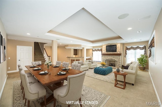 dining space with light colored carpet, baseboards, a raised ceiling, and recessed lighting