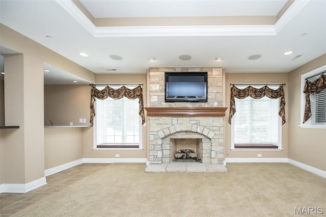 unfurnished living room featuring ornamental molding, a fireplace, a tray ceiling, recessed lighting, and carpet