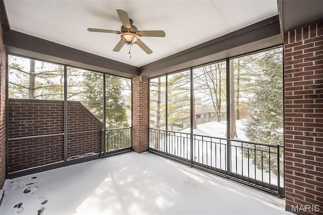 unfurnished sunroom with ceiling fan