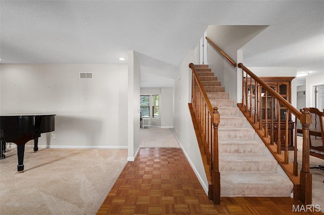 stairs featuring baseboards, a textured ceiling, and recessed lighting