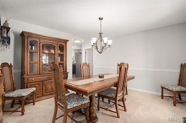 dining space with a chandelier, light carpet, and baseboards