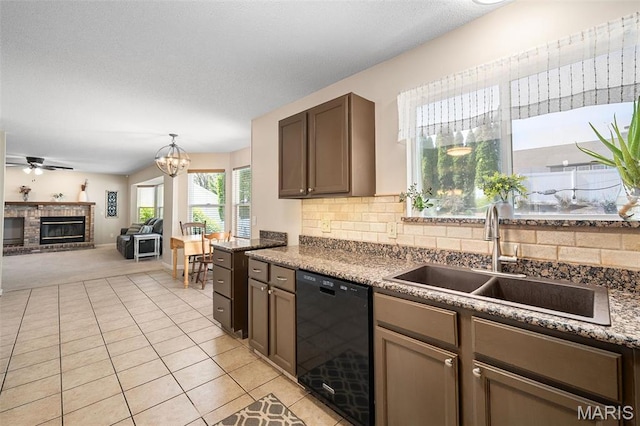 kitchen featuring black dishwasher, a sink, light colored carpet, backsplash, and a brick fireplace