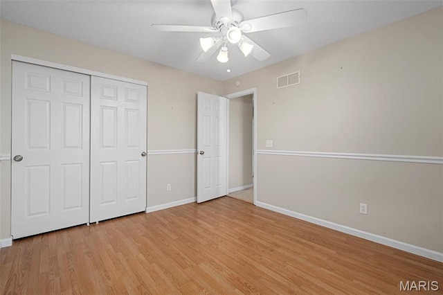unfurnished bedroom featuring light wood-style floors, baseboards, a closet, and ceiling fan