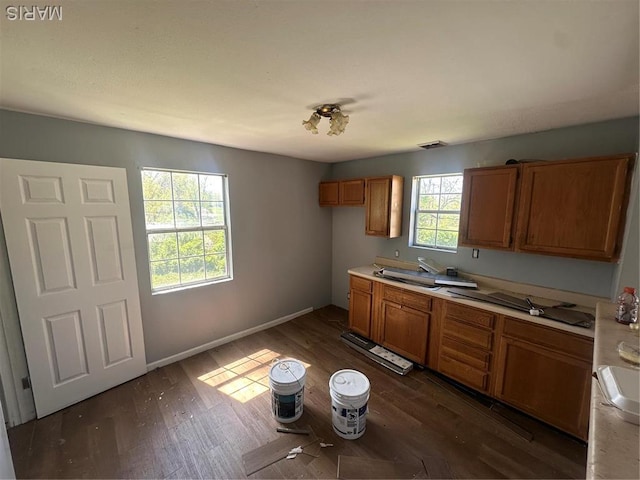 8818 Kendale Dr, Saint Louis, MO 63121 - kitchen with brown cabinets, light countertops, dark wood finished floors, and a sink