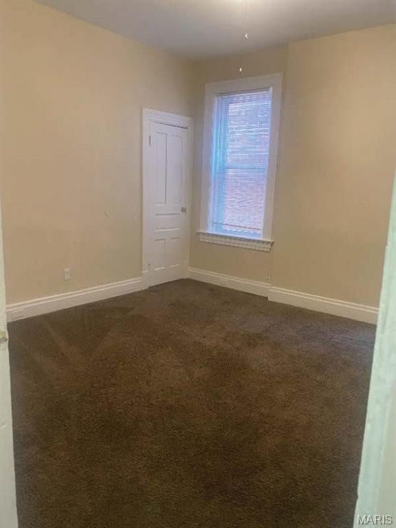 1208 N Euclid Ave, Saint Louis, MO 63113 - unfurnished room with dark colored carpet and baseboards