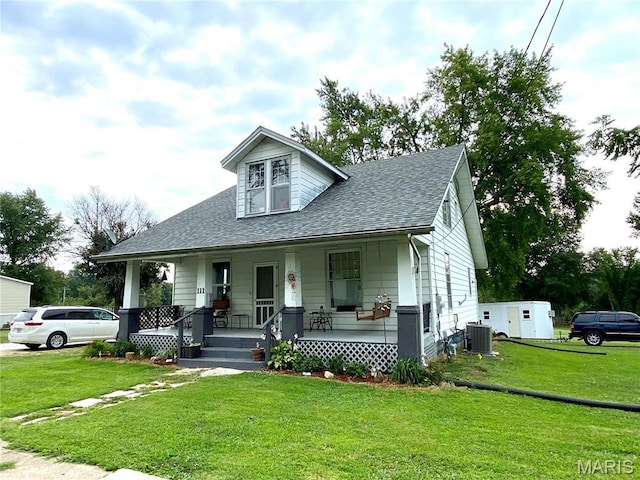 111 SE St, Wellsville, MO 63384 - bungalow-style home with central AC unit, covered porch, a shingled roof, and a front yard