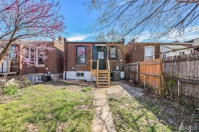 4021 Winnebago St, Saint Louis, MO 63116 - rear view of house with a fenced backyard, brick siding, and central AC