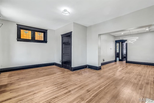 4021 Winnebago St, Saint Louis, MO 63116 - unfurnished room with hardwood / wood-style floors, baseboards, and a chandelier