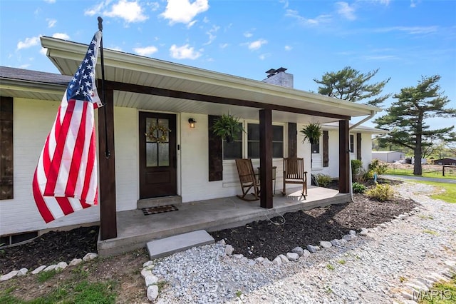 view of front of house with covered porch and a chimney