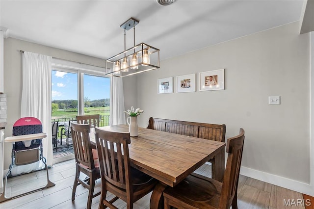 dining room with a chandelier and baseboards