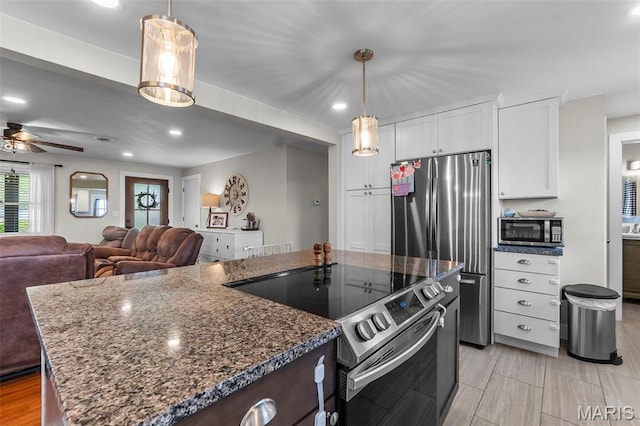 kitchen with appliances with stainless steel finishes, white cabinets, a ceiling fan, open floor plan, and recessed lighting