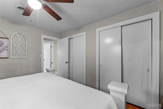 bedroom with two closets and ceiling fan