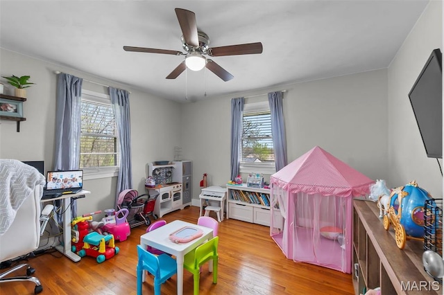 recreation room with healthy amount of natural light, light wood-style flooring, and ceiling fan