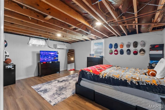bedroom with wood finished floors and a wall mounted AC