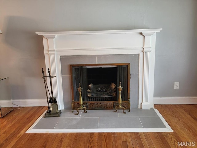 8303 Knollwood Dr, Saint Louis, MO 63121 - detailed view of a fireplace, wood finished floors, and baseboards