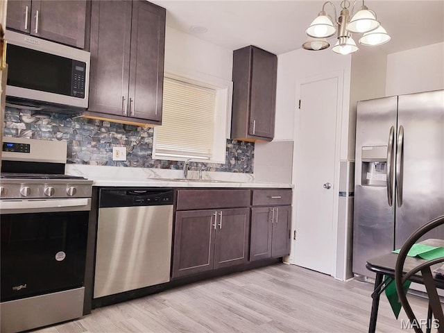 8303 Knollwood Dr, Saint Louis, MO 63121 - kitchen featuring appliances with stainless steel finishes, a sink, light countertops, and dark brown cabinetry