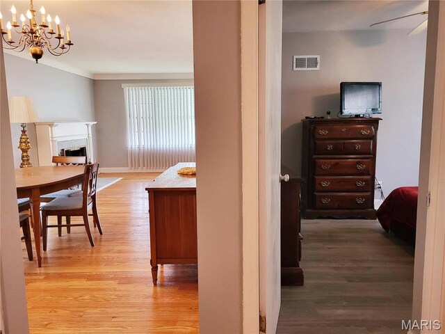 8303 Knollwood Dr, Saint Louis, MO 63121 - corridor featuring light wood finished floors and a chandelier