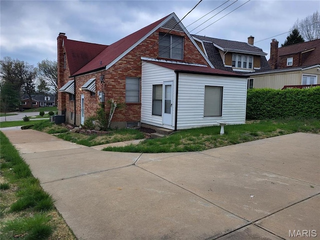 8303 Knollwood Dr, Saint Louis, MO 63121 - view of property exterior featuring brick siding, a chimney, and central AC
