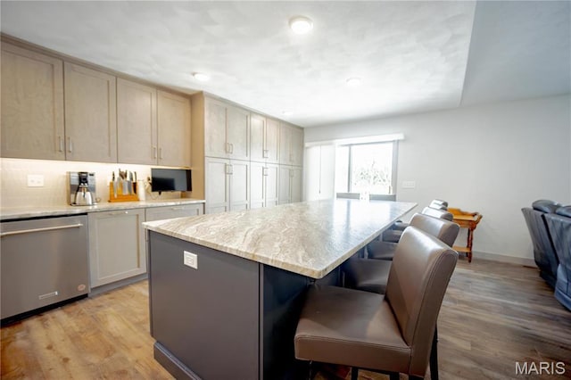 5826 Grandview Ter, Waterloo, IL 62298 - kitchen featuring dishwasher, a breakfast bar area, a center island, light stone countertops, and light wood-style floors