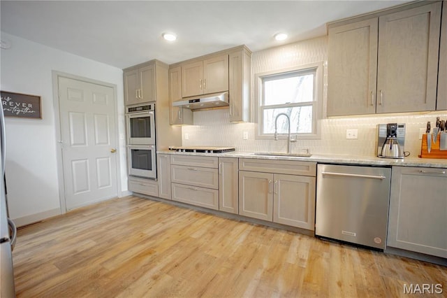 5826 Grandview Ter, Waterloo, IL 62298 - kitchen featuring stainless steel appliances, under cabinet range hood, a sink, backsplash, and light wood finished floors