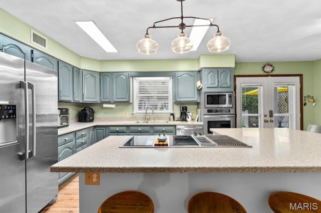 411 S High St, Belleville, IL 62220 - kitchen with stainless steel appliances, a kitchen bar, a sink, and gray cabinetry