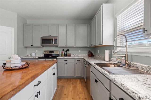 809 Colony Ridge Ct, Foristell, MO 63348 - kitchen with appliances with stainless steel finishes, butcher block counters, a sink, light wood-type flooring, and gray cabinets