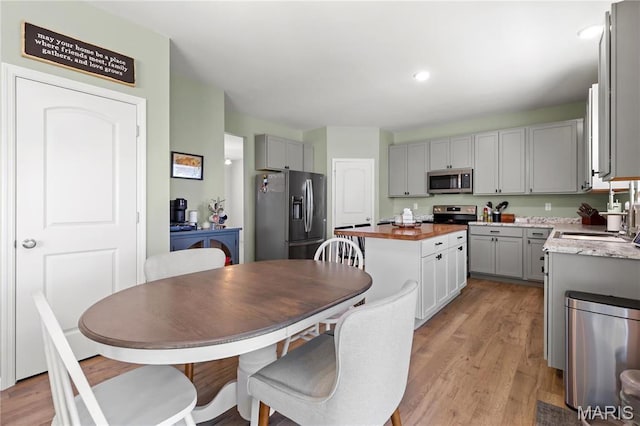 809 Colony Ridge Ct, Foristell, MO 63348 - kitchen featuring stainless steel appliances, a sink, a center island, gray cabinets, and light wood-style floors