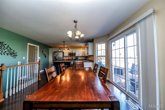 2605 Buenger Blvd, Granite City, IL 62040 - dining area featuring a chandelier, dark wood-type flooring, and baseboards