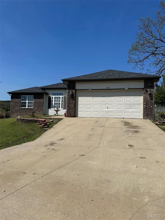 142 Oregon Ln, Kimberling City, MO 65686 - view of front of house with brick siding, driveway, and an attached garage