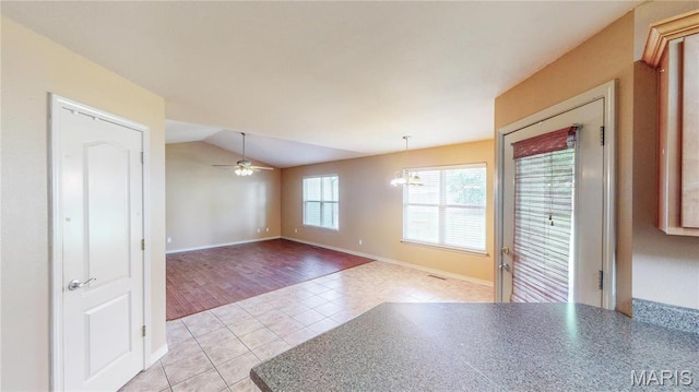 142 Oregon Ln, Kimberling City, MO 65686 - spare room with light tile patterned floors, lofted ceiling, ceiling fan, a chandelier, and baseboards