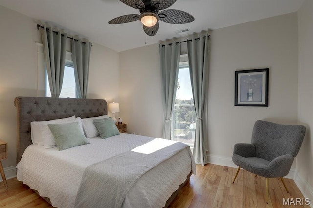 bedroom with baseboards, light wood finished floors, and a ceiling fan