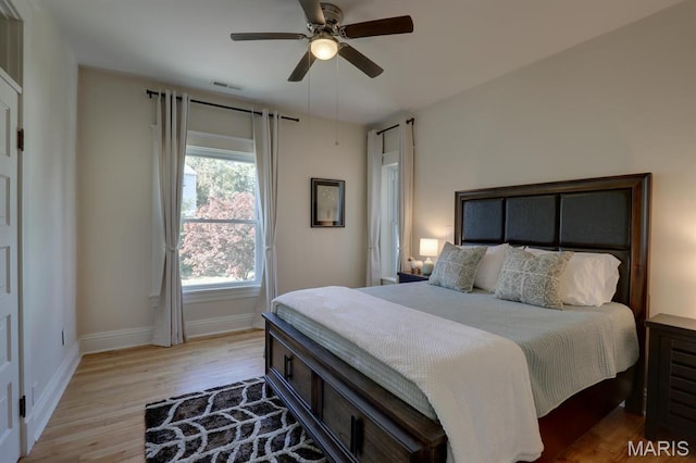 bedroom with light wood-type flooring, baseboards, and a ceiling fan