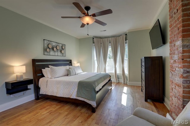 bedroom with light wood-style floors, crown molding, baseboards, and ceiling fan
