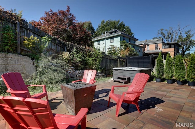 view of patio / terrace featuring a hot tub, a fire pit, and a fenced backyard