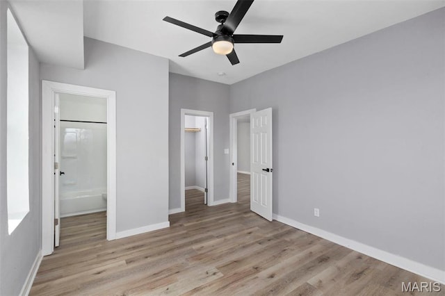 unfurnished bedroom with wood finished floors, baseboards, ceiling fan, and a closet