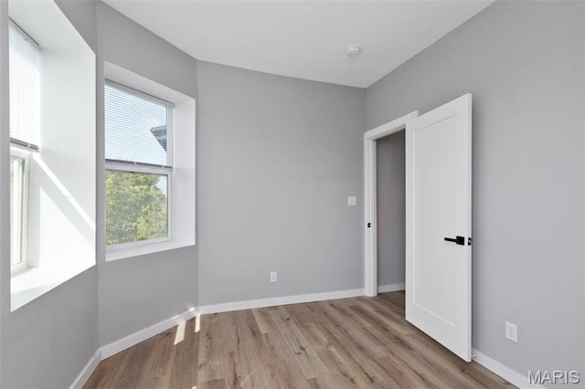 spare room with wood finished floors and baseboards